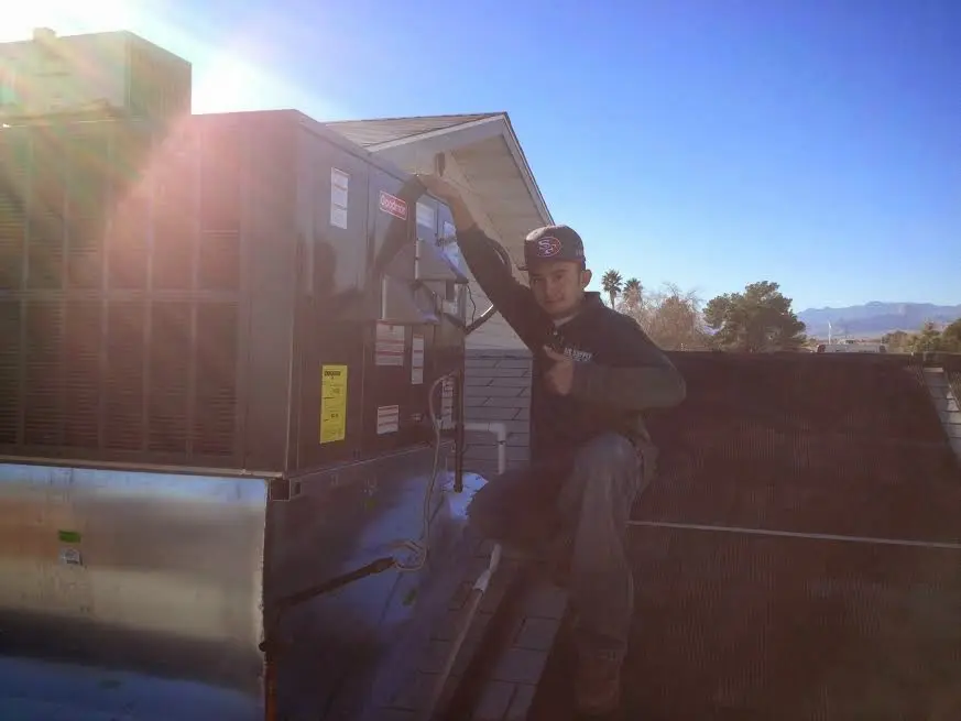 HVAC technician performing AC Tune-Up on a rooftop unit in Jackson
